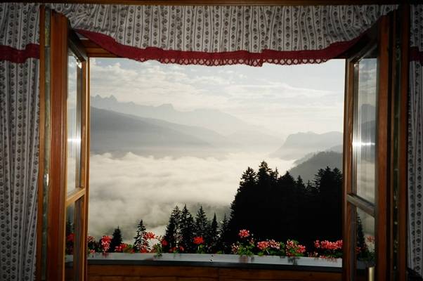 נוף הרים ועננים מחלון צימר באוסטריה